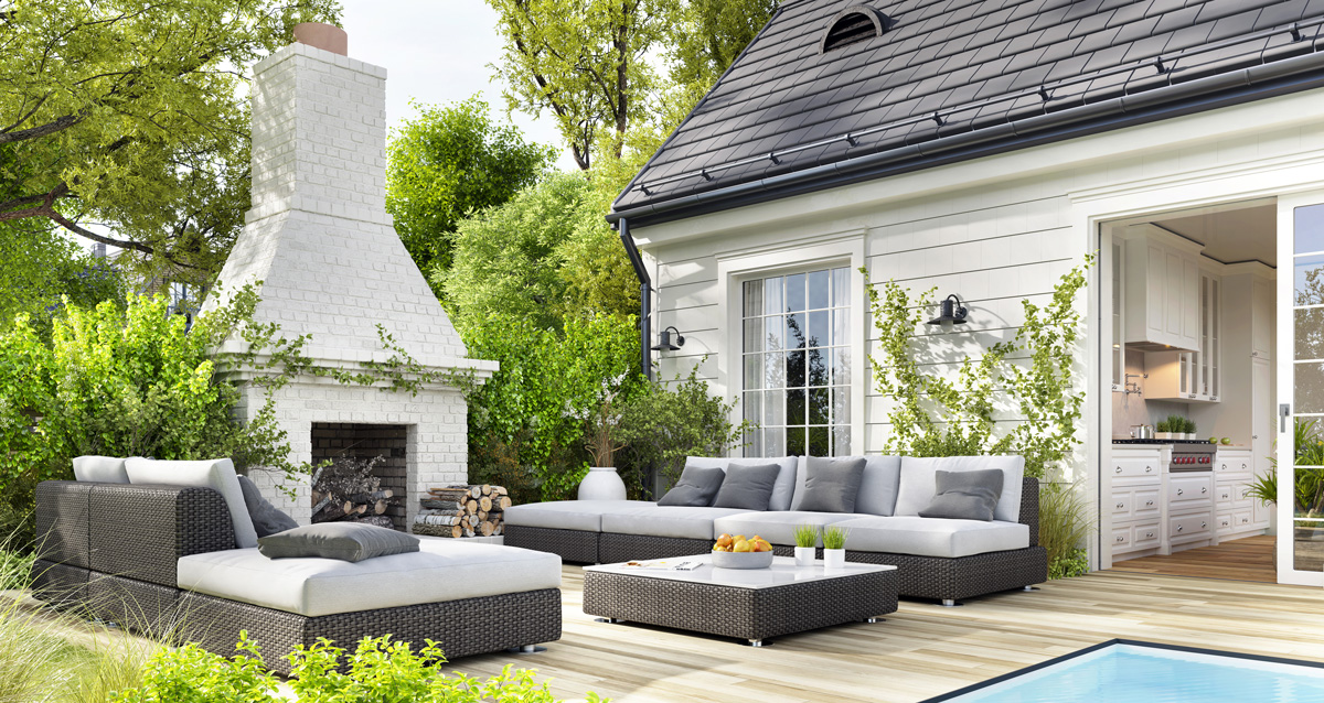 The outdoor patio of an El Paso model home with furniture and a white outdoor fireplace.
