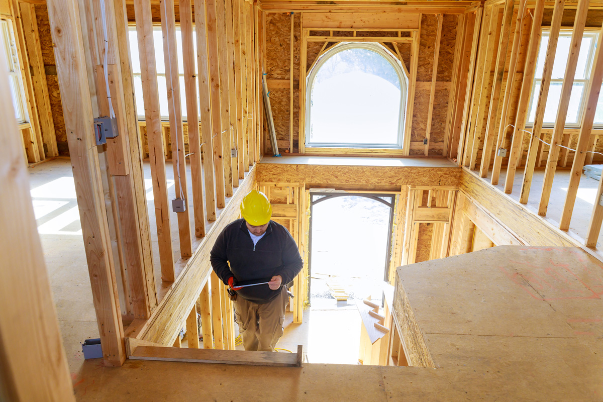 A new home contractor walking through the frame of a new home in El Paso.